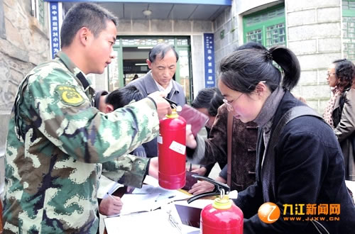 消防官兵为居民发放灭火器